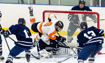 Thayer junior C Jay O'Brien crashes into Andover PG goalie Kyle Martin.