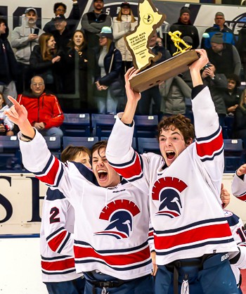 LA captains Sam Marchionni and Clarence Beltz celebrate the Spartans' 4-3 OT win over Frederick Gunn in the 2023 Small School Championship game Sunday