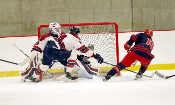 Dexter senior goaltender Kyle Ready fends off Gunn junior forward Lukas Reisen in Sunday's 4-4 tie at The Exeter Invitational. Note: KUA, by winning a